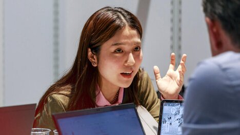 Junge Frau im Gespräch, beide mit Laptop