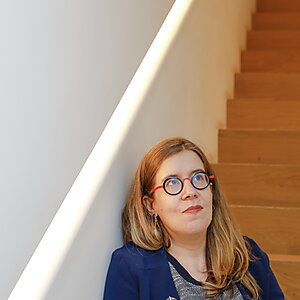 Frau im Treppenhaus rote lange Haare Brille Anne Lise Remacle